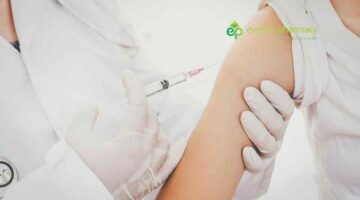 Woman getting travel vaccine administered in upper arm.