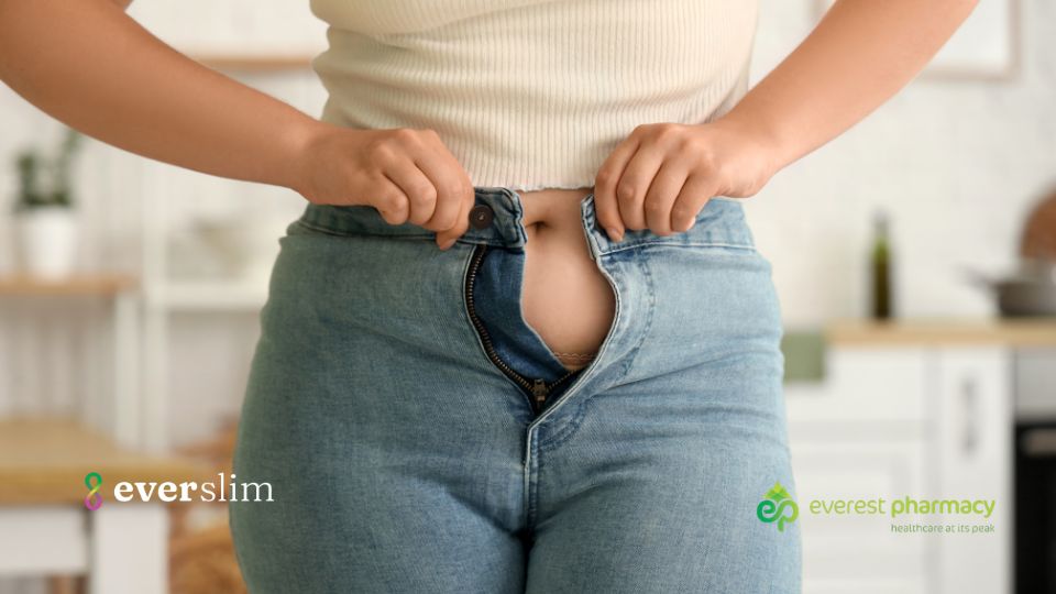 Woman doing up jeans that are too tight