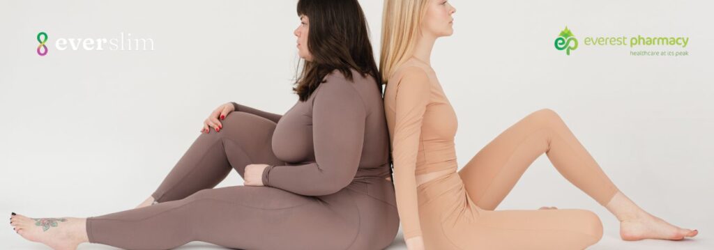Two women sitting back to back comparing body types before and after weight loss