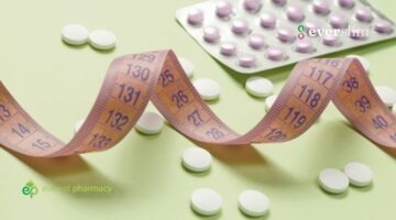white pills on green background with measuring tape